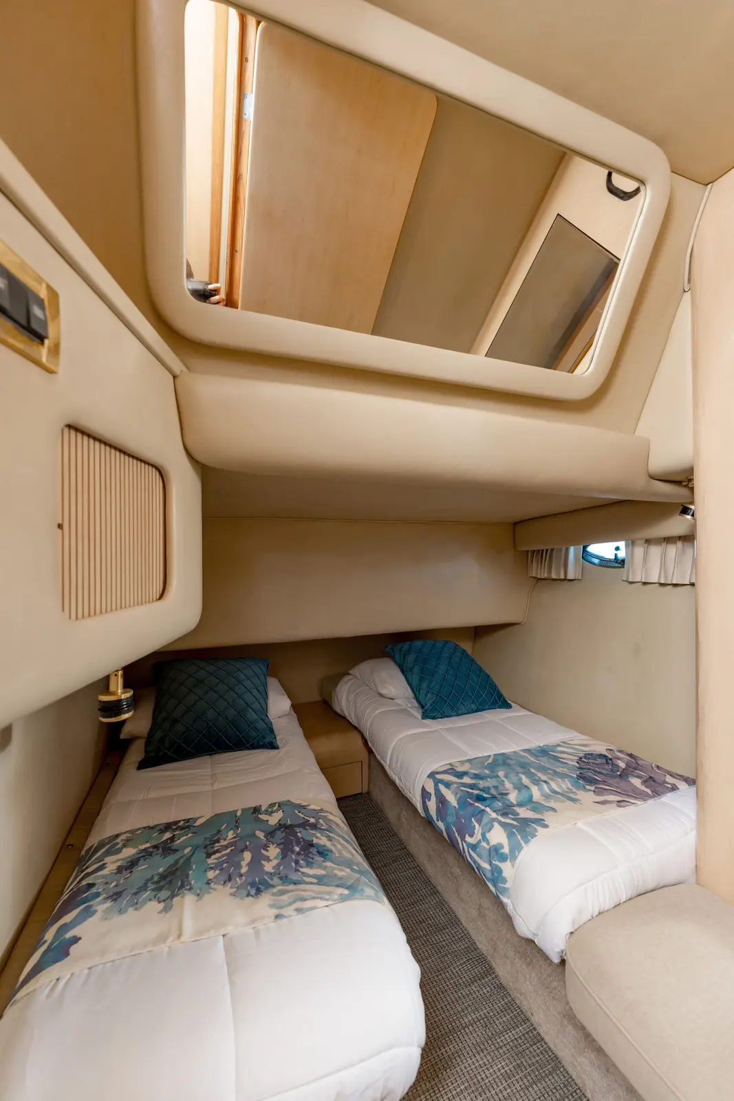 Twin guest cabin aboard the yacht with two single berths and patterned bedspreads