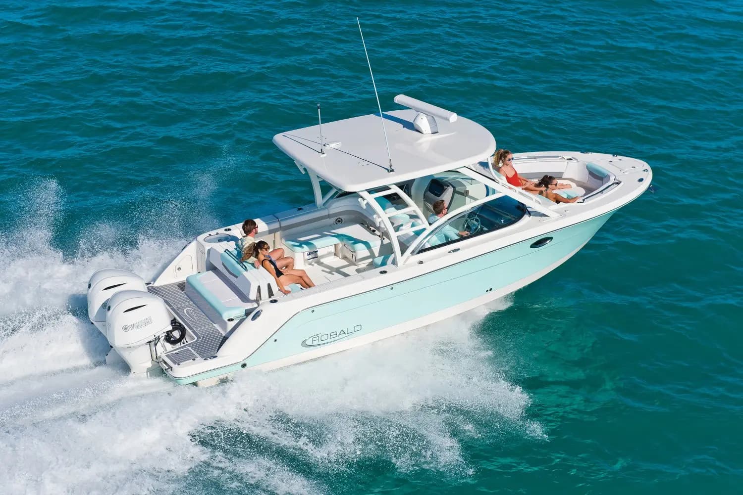 Guests aboard a twin-outboard center-console boat speeding across turquoise water off Costa Rica