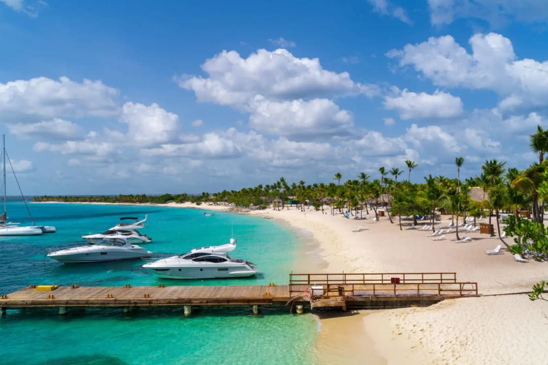 Private Saona Island Excursion with luxury yachts anchored beside a pristine white sand beach and turquoise Caribbean waters.