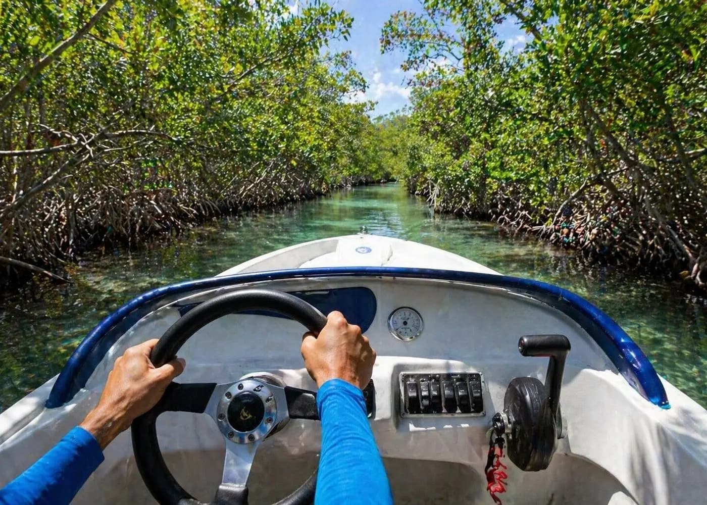 Driver's view from a small speedboat steering through a narrow mangrove channel in Nichupté Lagoon