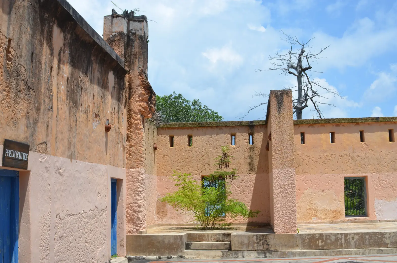 Weathered ochre walls of the old prison building around a courtyard on Prison Island