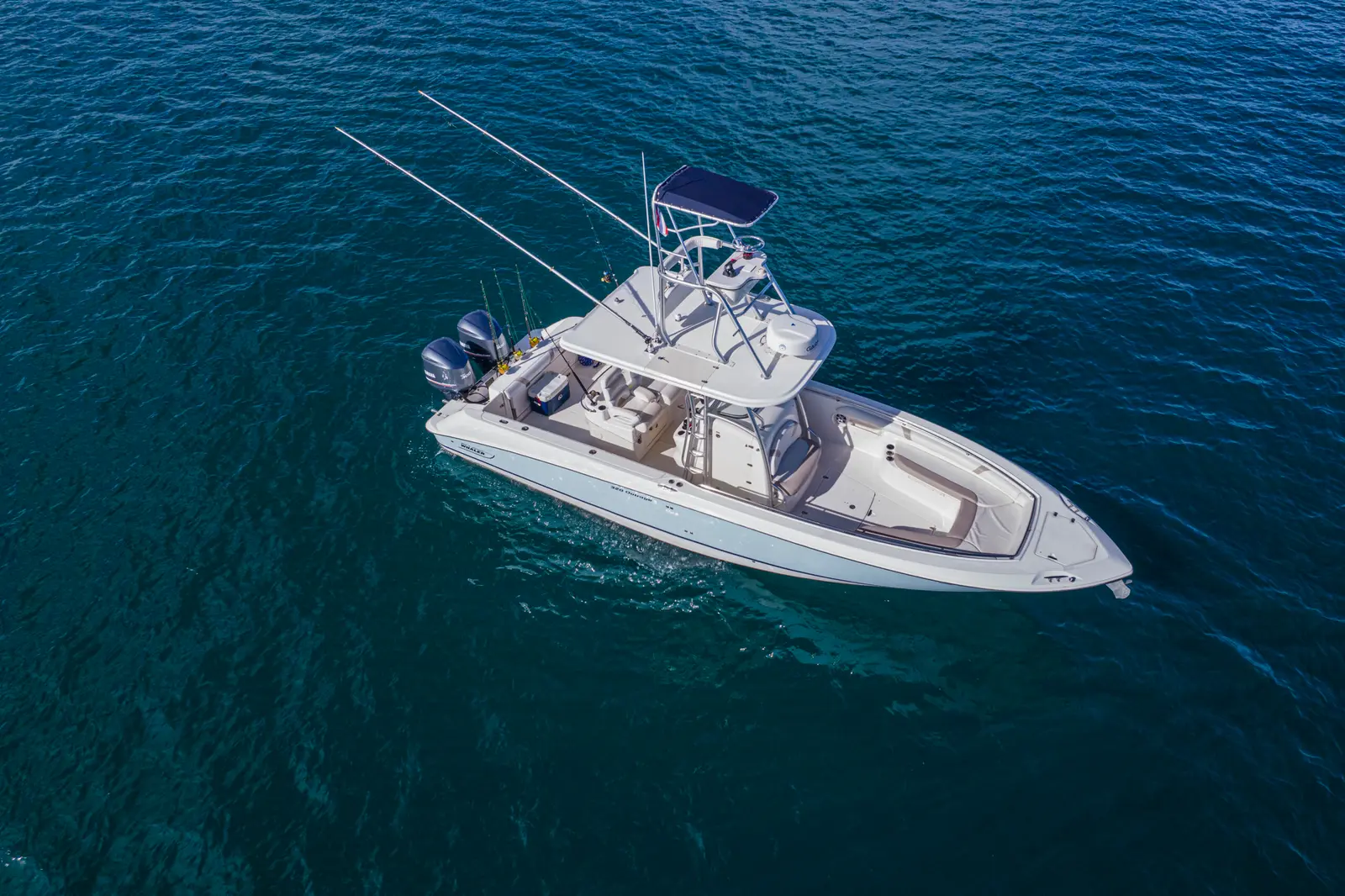 Aerial view of a center-console fishing boat with outriggers cruising over deep blue water off Costa Rica
