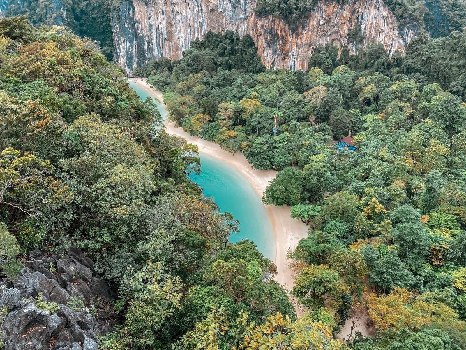 Hong Lagoon's turquoise channel winding through dense jungle beneath limestone cliffs, seen from above