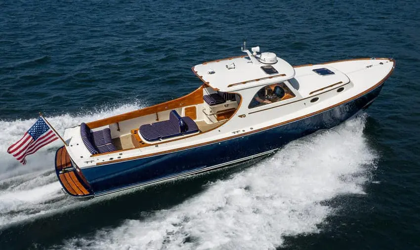 Navy-hulled picnic boat with varnished wood trim speeding across deep blue water off Costa Rica