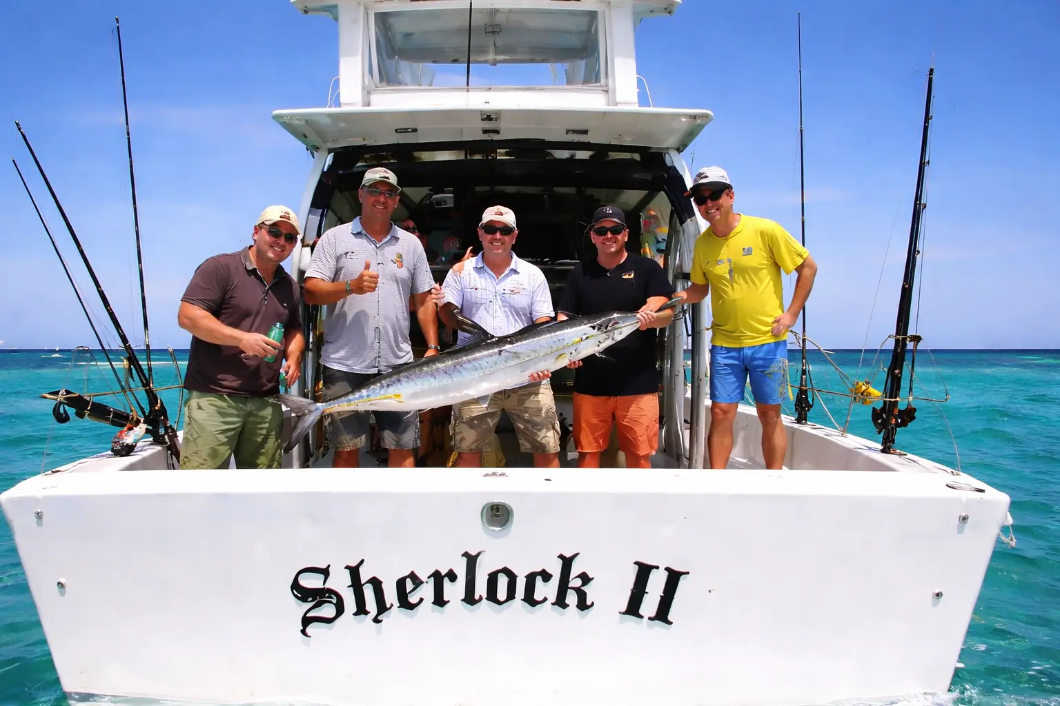 Five anglers posing at the stern of the sportfishing boat with a long silver fish