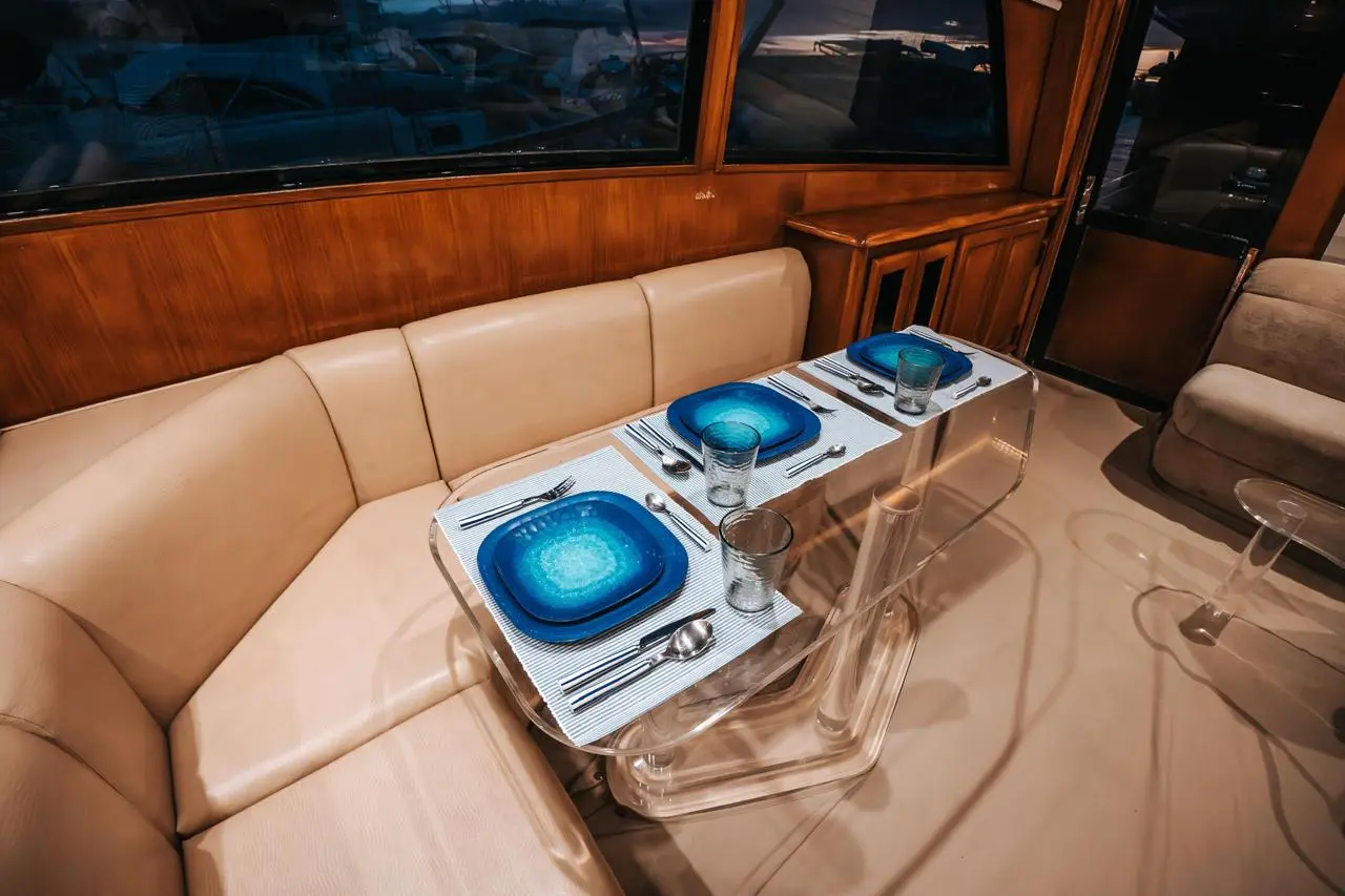 Cream leather settee around a clear acrylic table set with blue plates in the yacht's saloon