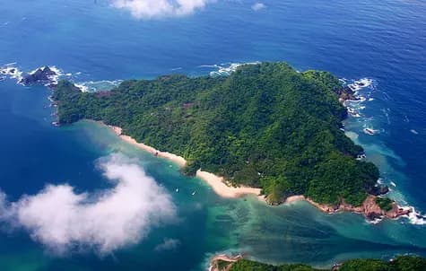 Aerial view of a forested island ringed by white-sand beaches and turquoise shallows off Costa Rica