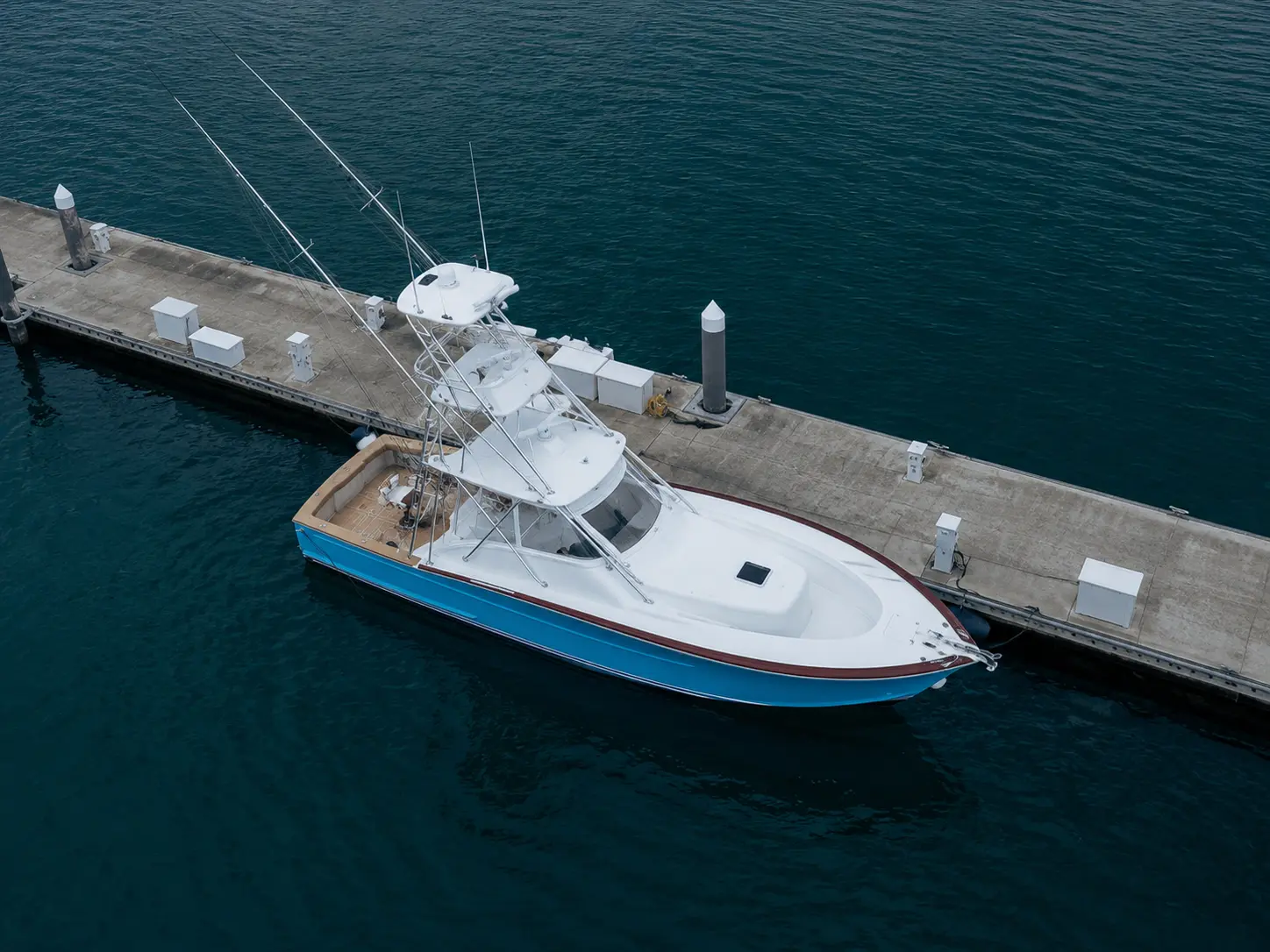 Aerial view of a sportfishing boat with outriggers tied up at a marina dock in Costa Rica