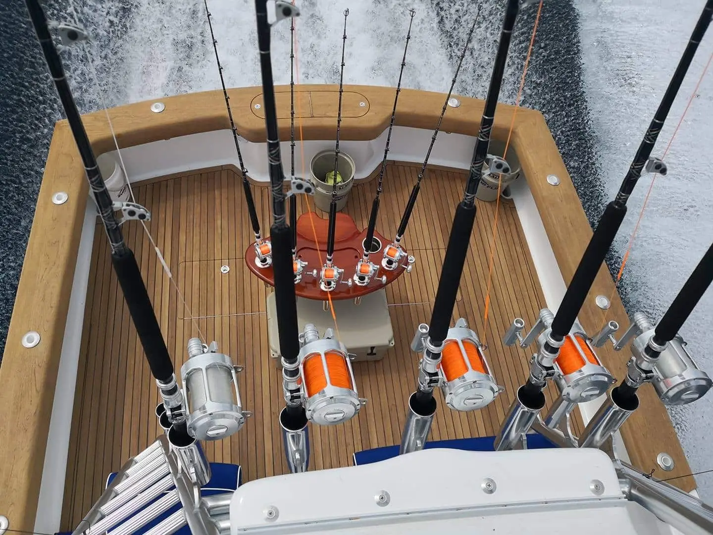 Overhead view of the sportfishing boat's teak cockpit with heavy trolling rods set in holders