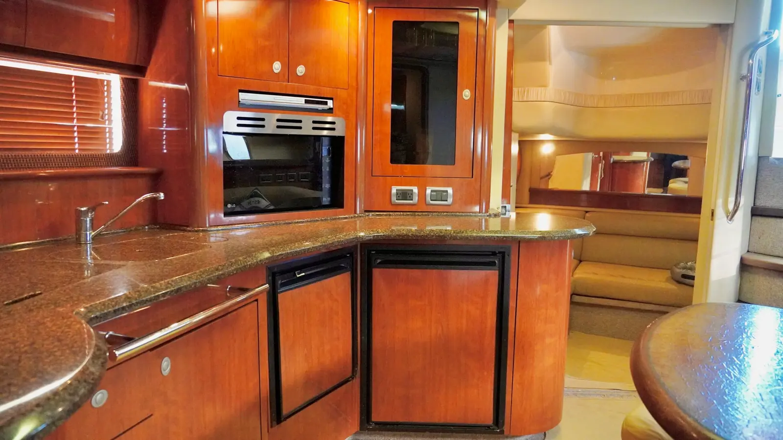 Galley with cherry wood cabinets, granite counters and a built-in oven below deck on a motor yacht