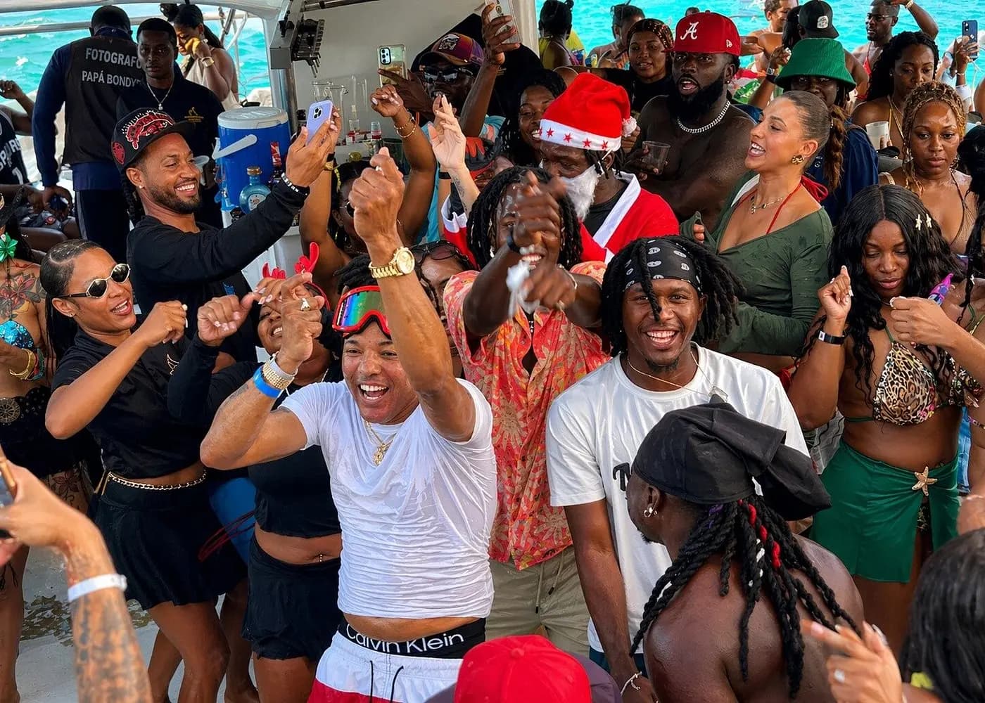 Packed crowd dancing on the party catamaran, one guest in a Santa hat