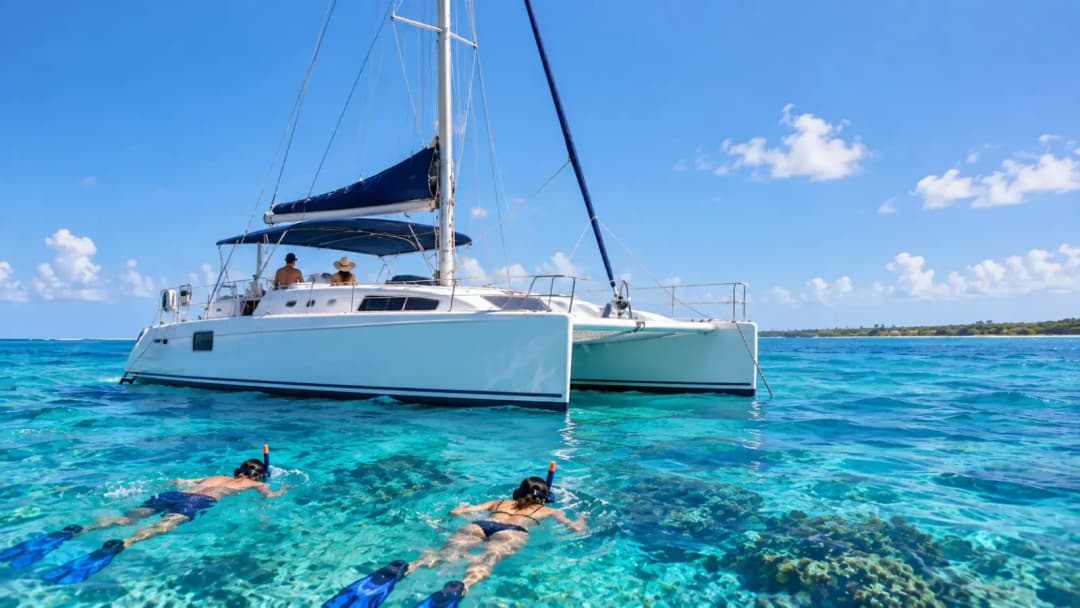 White catamaran with two snorkelers enjoying a Cozumel snorkeling tour in clear turquoise Caribbean water