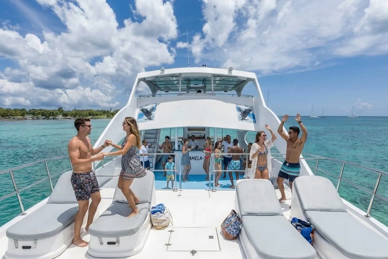 Guests dancing on the bow sun pads of the catamaran off Bayahibe