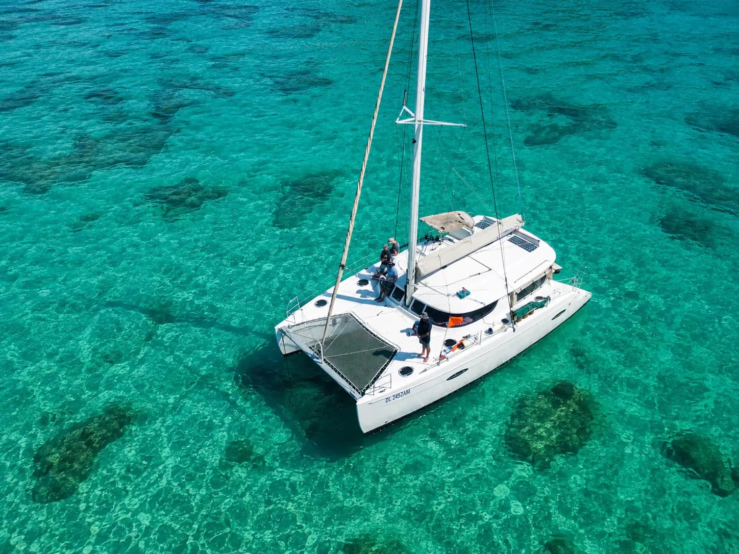 Catamaran anchored over coral reefs in turquoise water off Zanzibar
