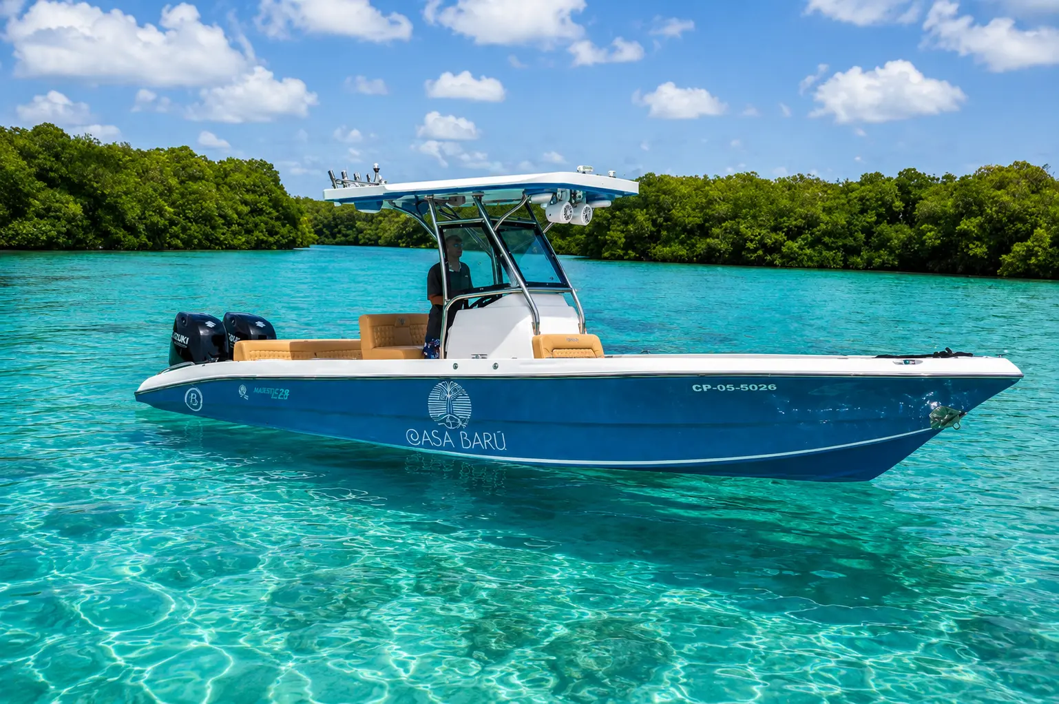Blue center-console speedboat anchored in clear turquoise water beside mangroves in the Rosario Islands