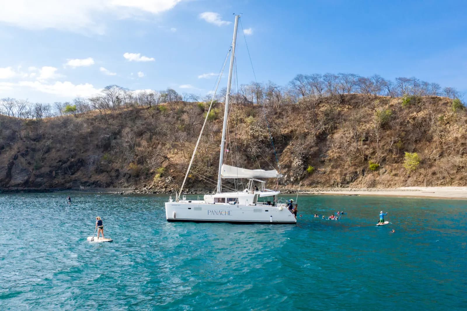 Sailing catamaran anchored in a bay with paddleboarders on a Costa Rica boat tour