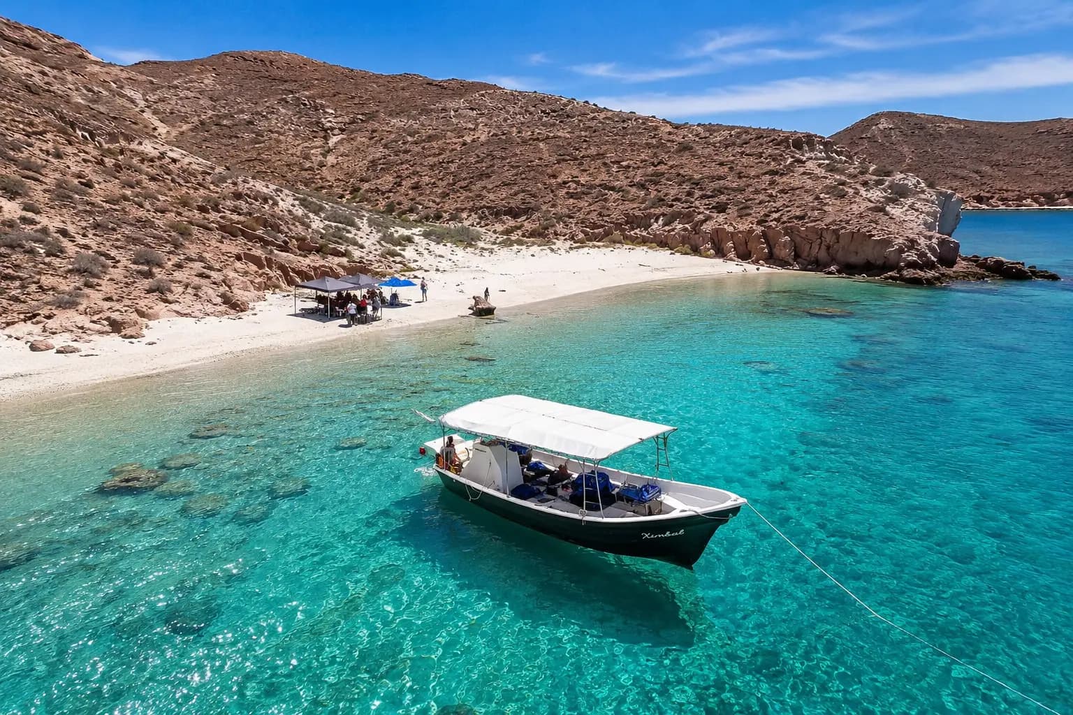 Canopied panga boat anchored in a turquoise cove off a white beach on Espiritu Santo Island