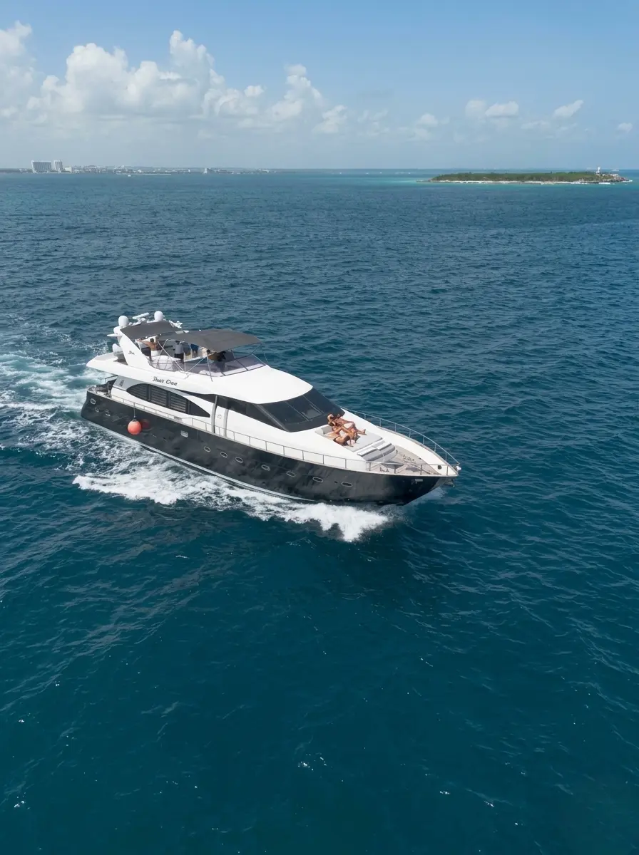 Aerial view of a dark-hulled motor yacht cruising toward the Punta Cana coast