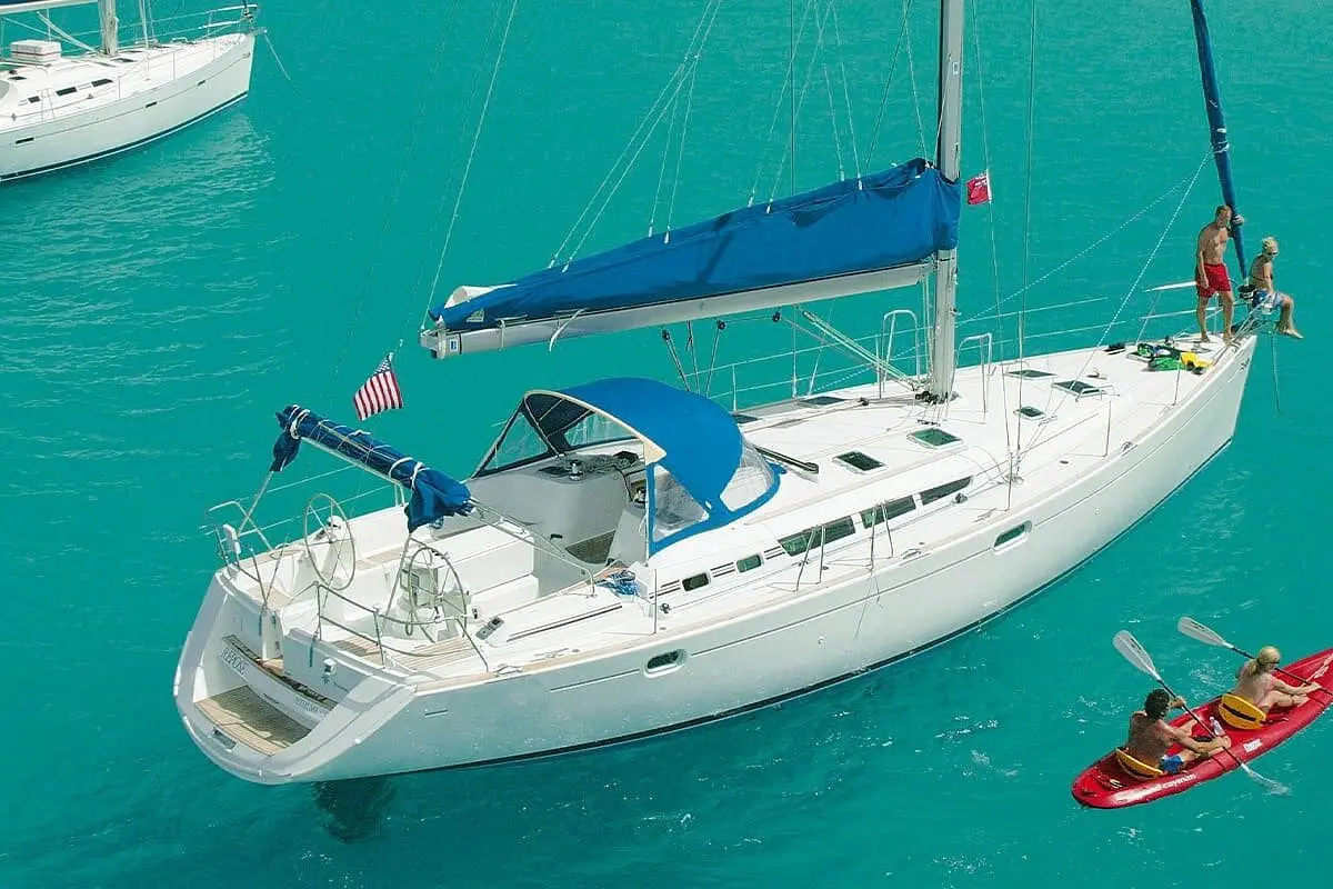 Aerial view of a sailboat anchored in turquoise water near La Paz as guests paddle a red kayak alongside