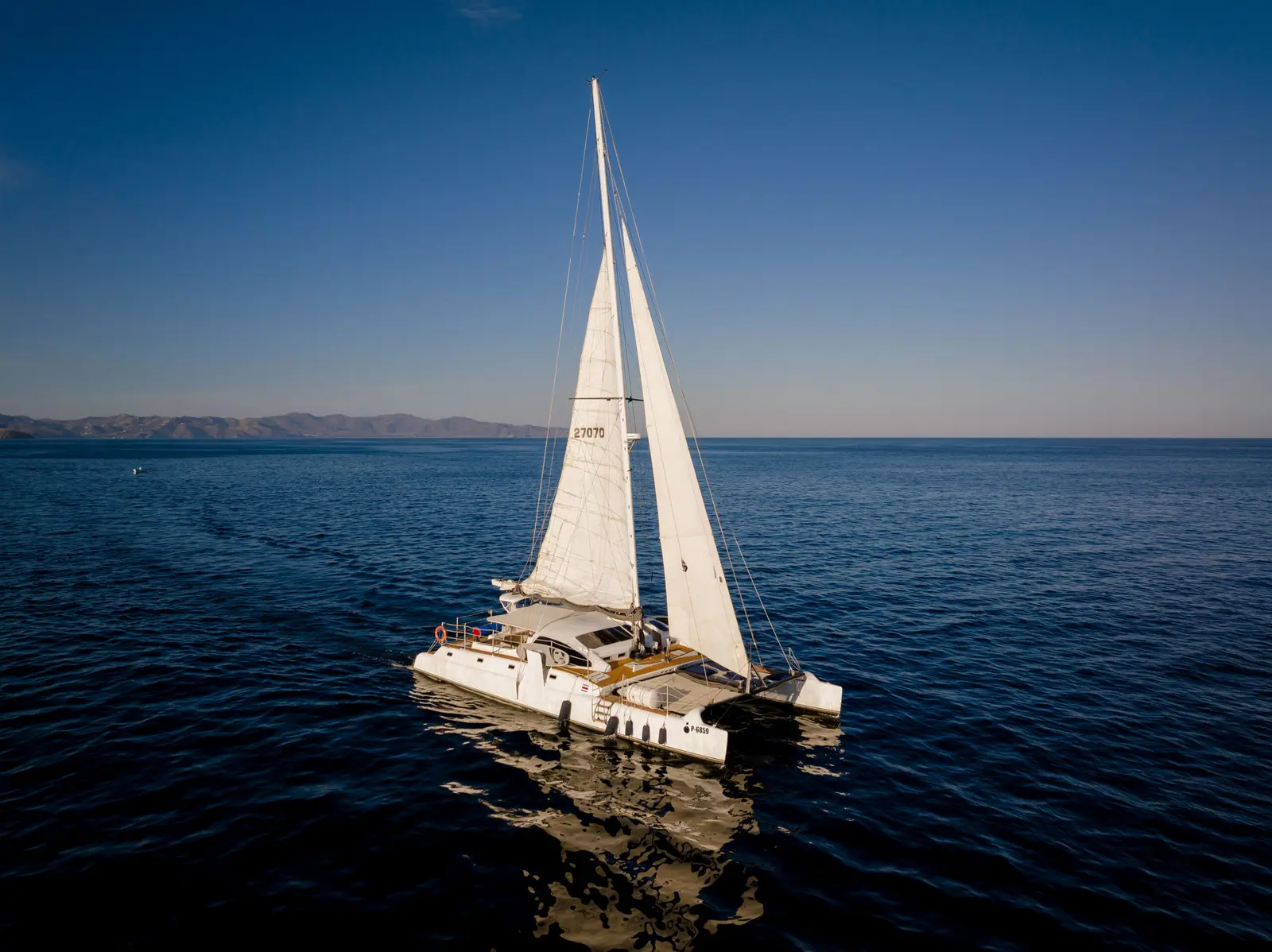 Sailing catamaran under full sail on deep blue water in the Gulf of Papagayo