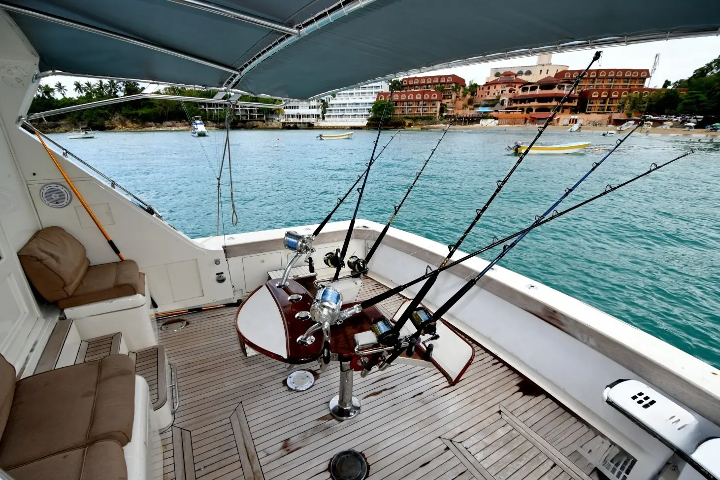 Fighting chair and rigged rods in the shaded cockpit of a sportfishing boat moored off Playa Sosua