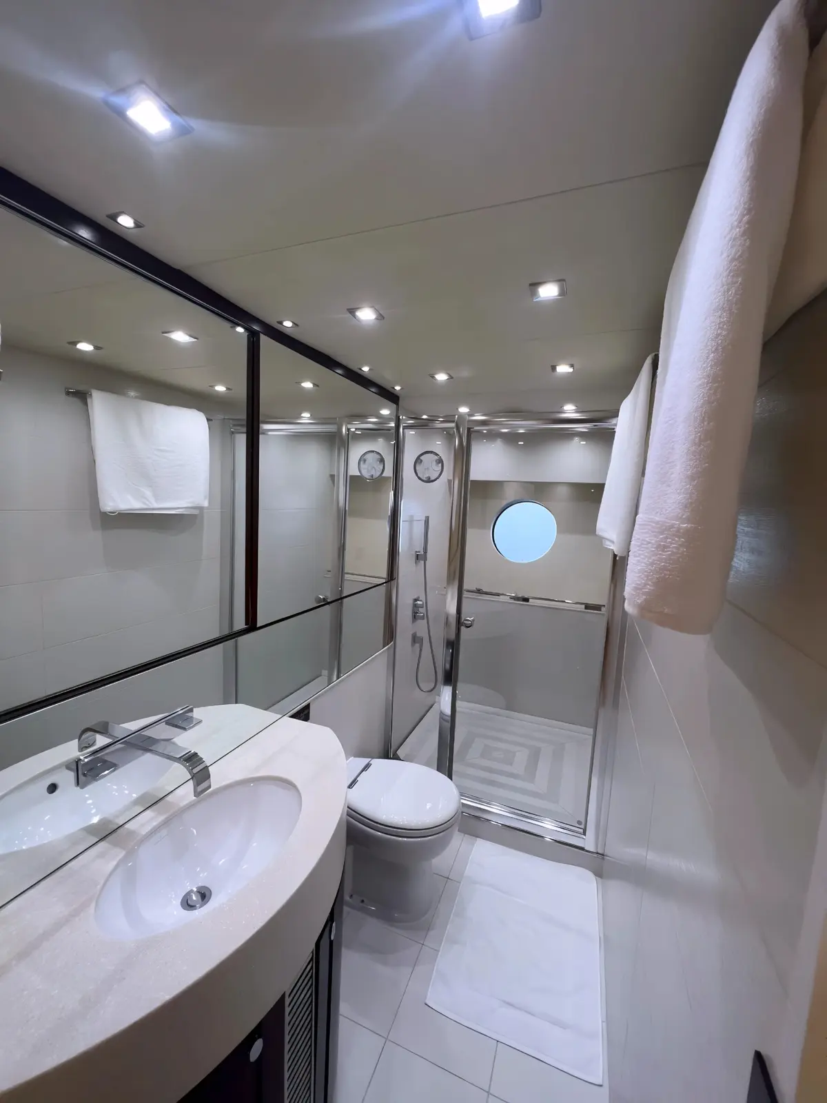Ensuite bathroom with a curved vanity, glass shower and porthole