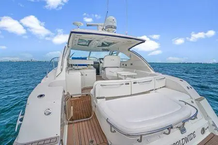Stern sun pad and hardtop cockpit of a motor yacht on open blue water
