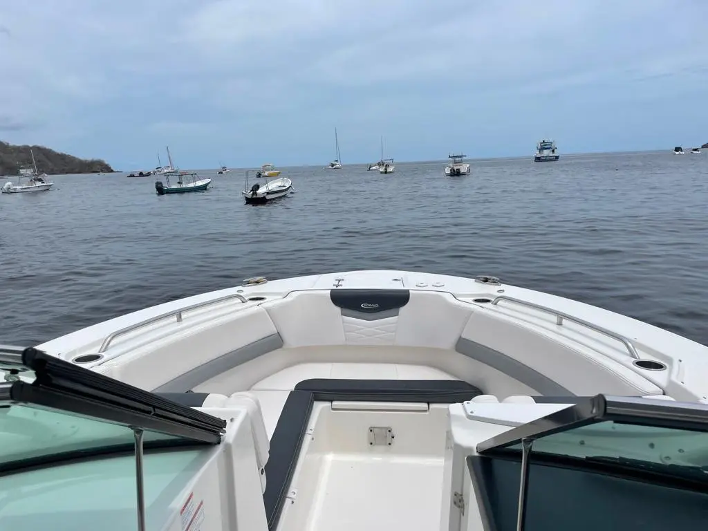 Bow seating of a dual console boat anchored in a calm Costa Rica bay dotted with moored boats