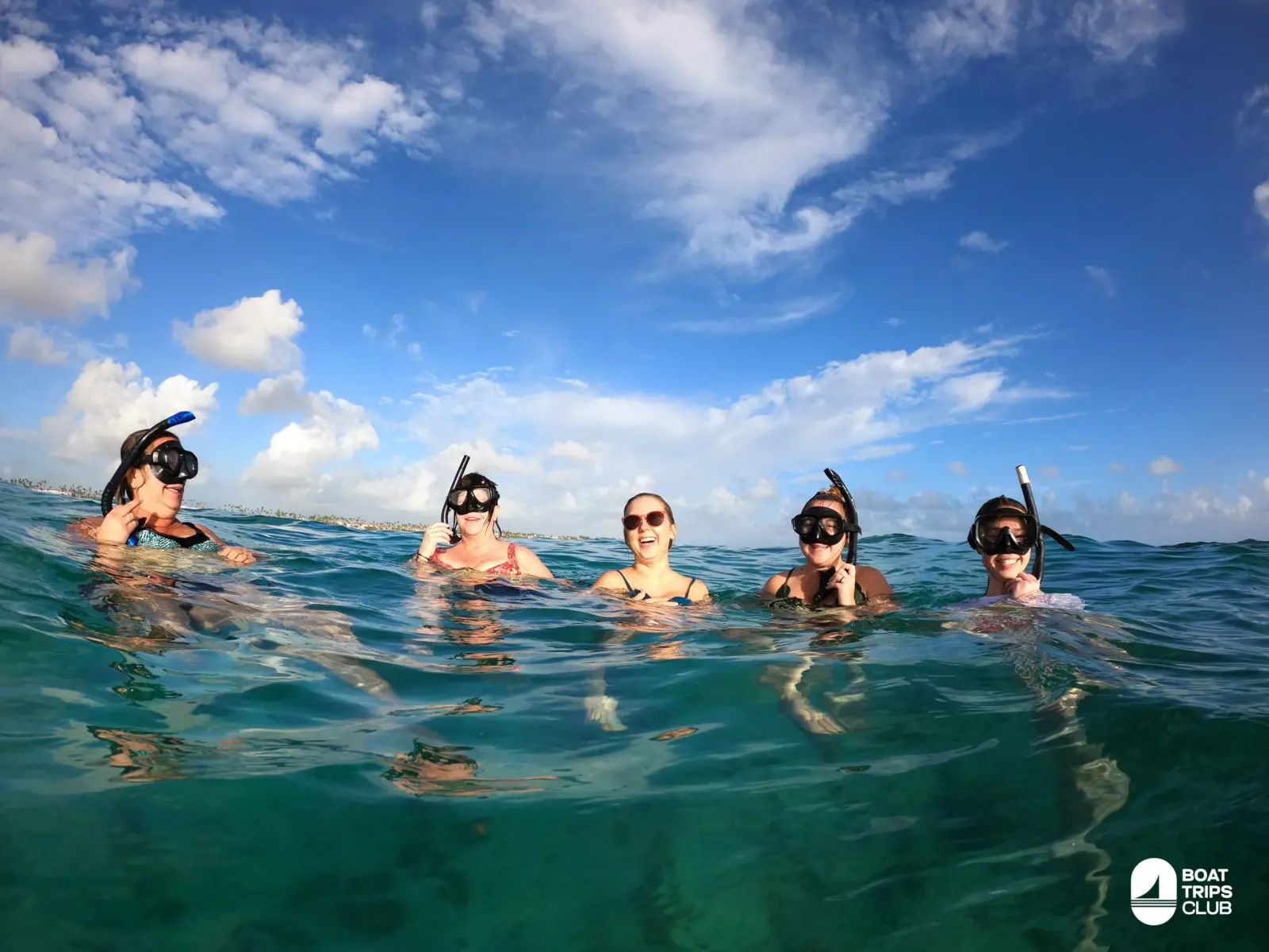 Group of snorkelers in masks bobbing at the surface of clear water off Punta Cana under a blue sky