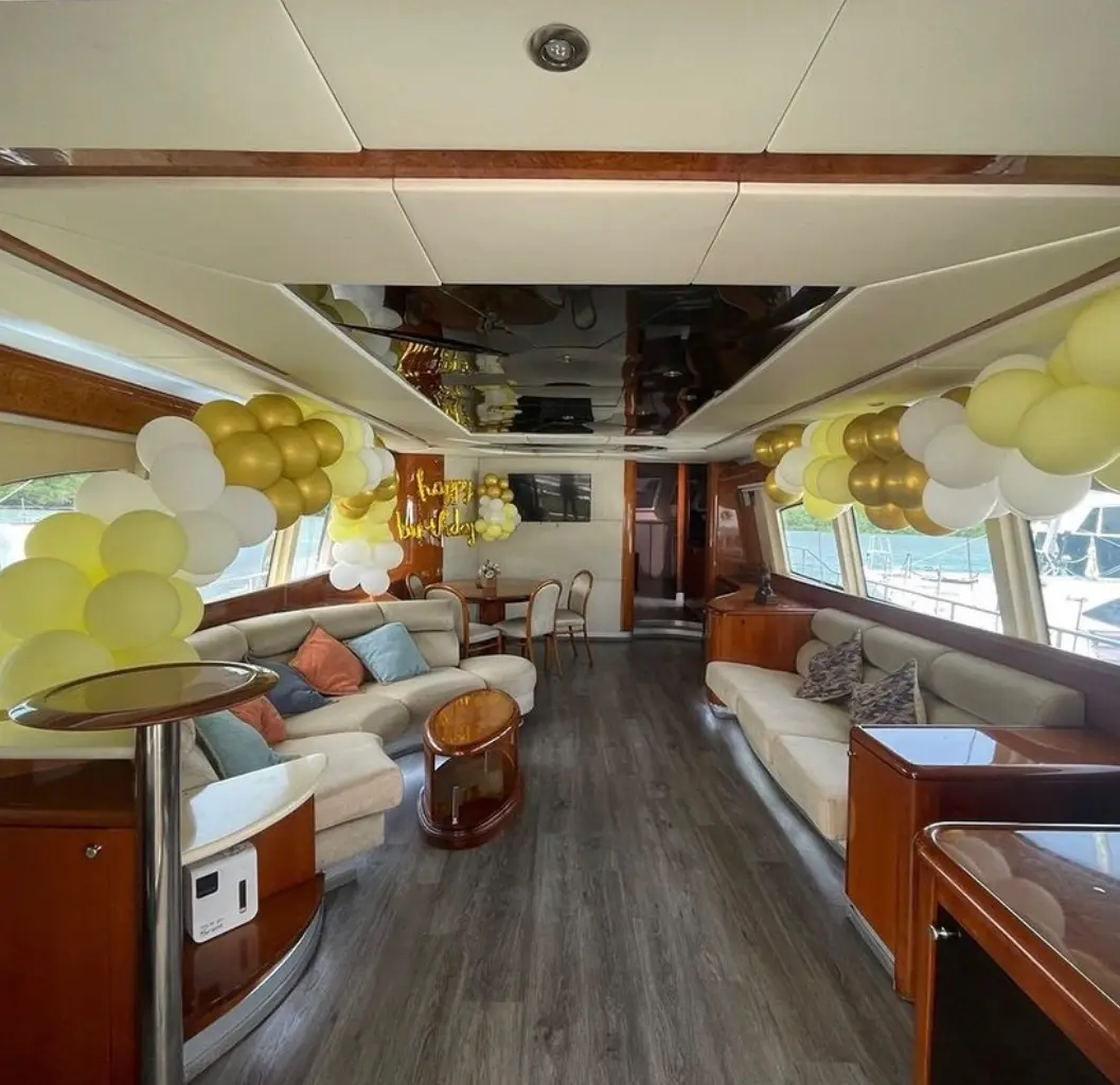 Yacht salon decorated with yellow, white and gold balloon garlands above the sofas