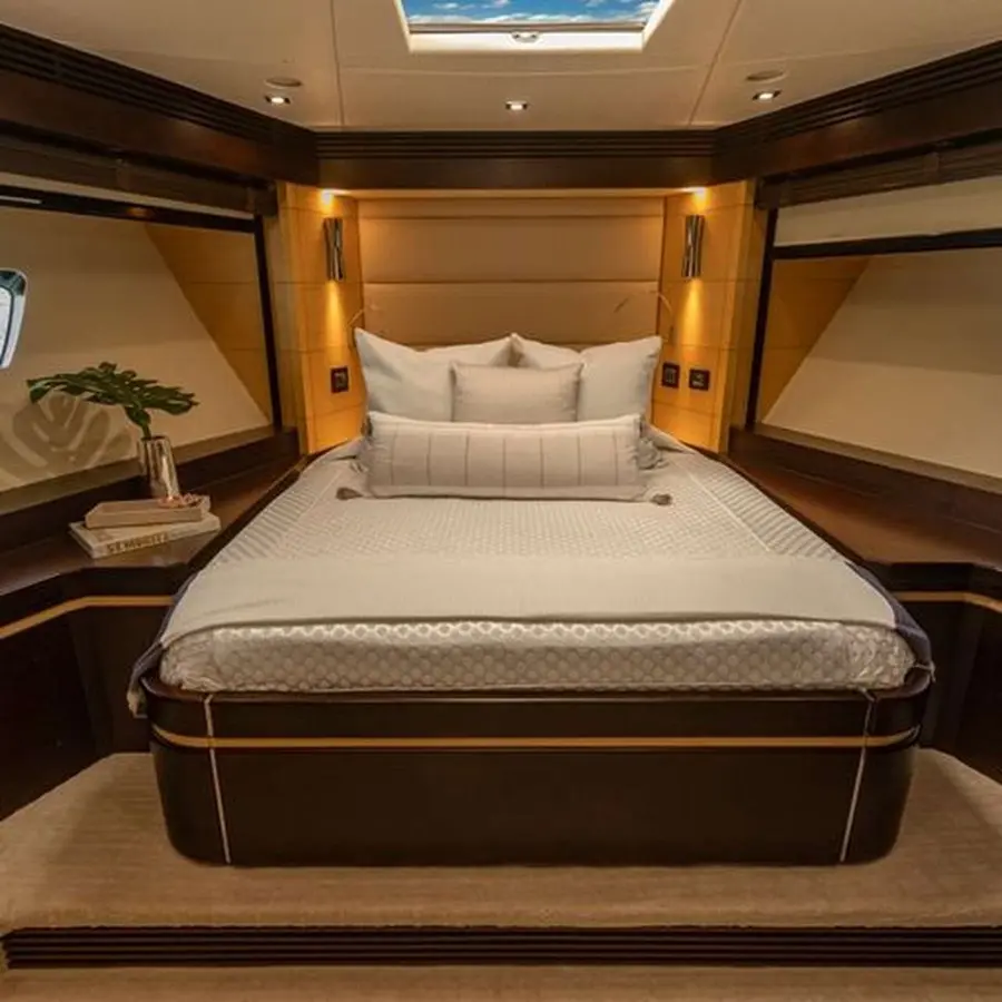 Master stateroom with a centered double bed, dark wood trim and a ceiling skylight