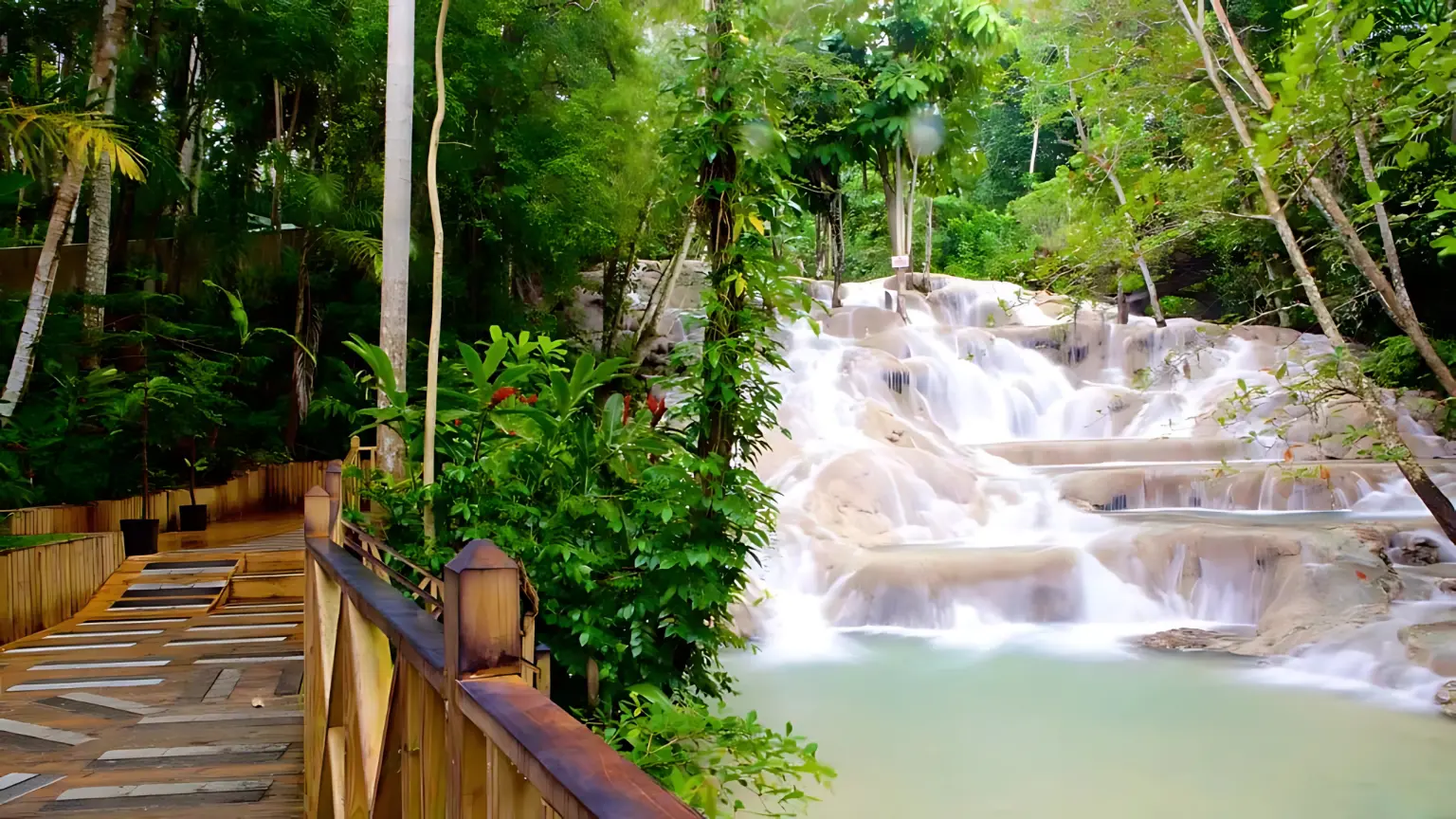 Dunn's River Falls cascading down limestone terraces beside a wooden forest walkway