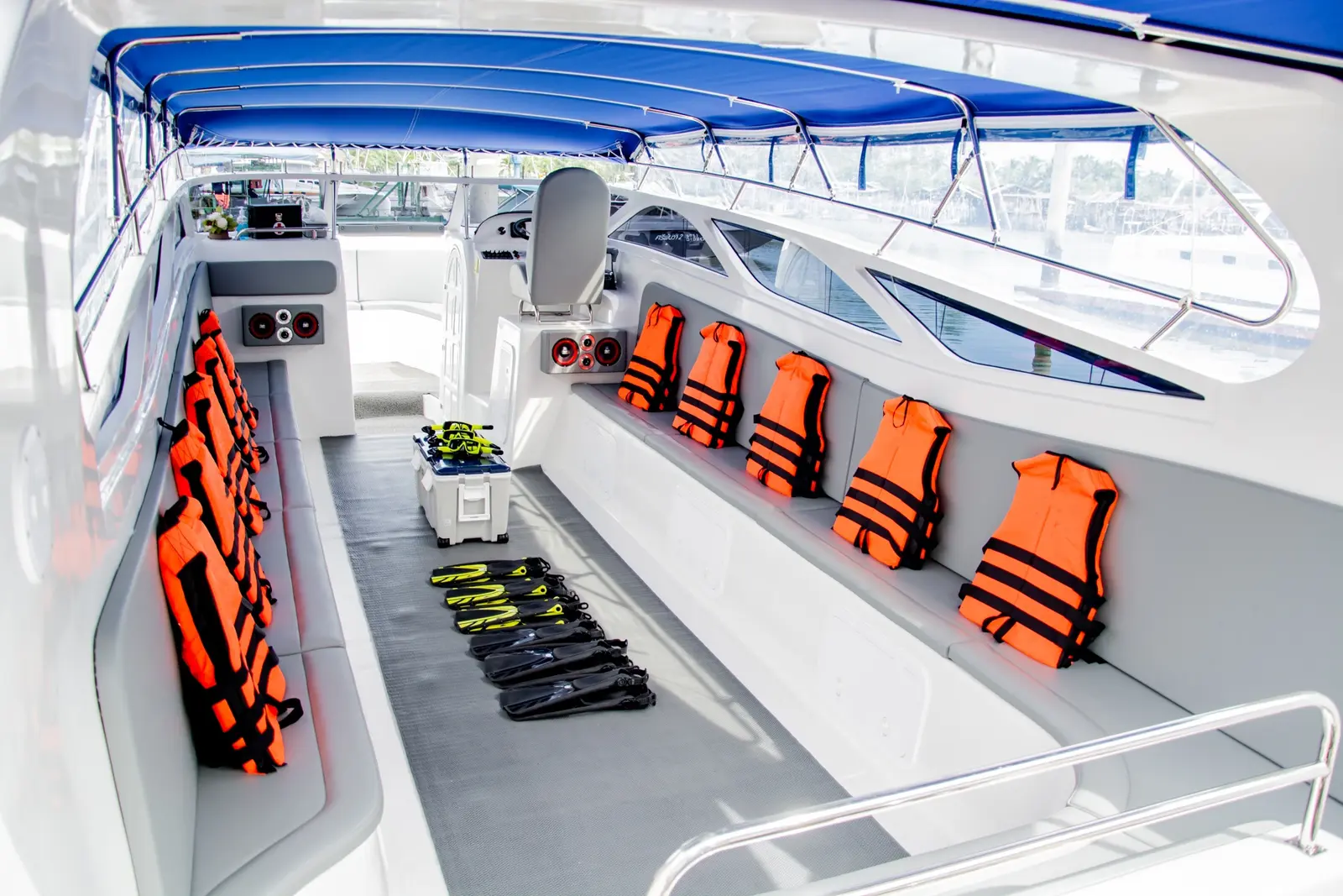 Speedboat cabin with orange life jackets hung along the benches and snorkel fins laid out on deck