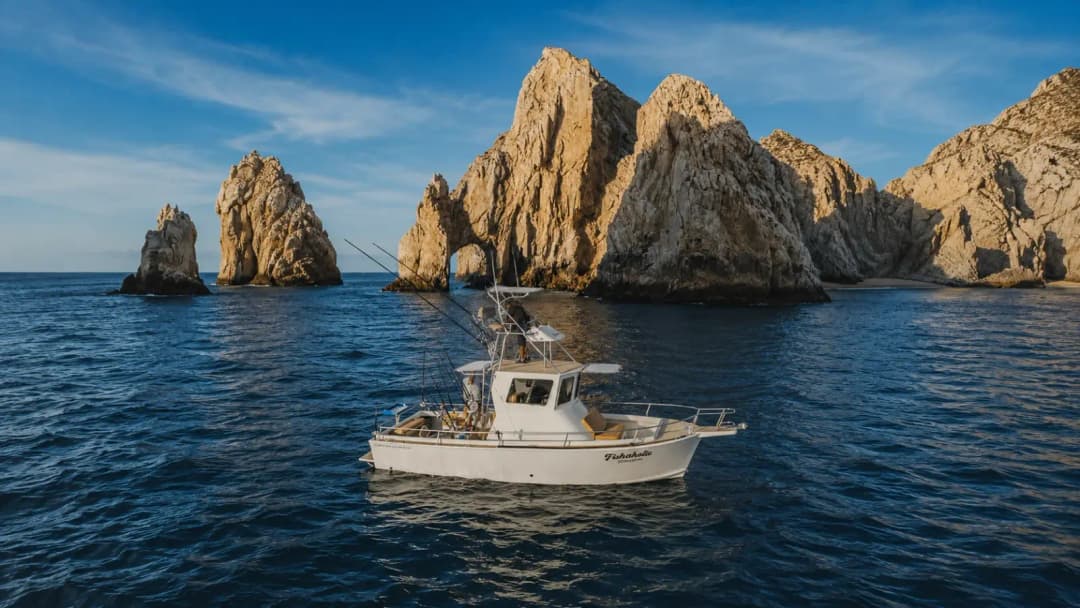 Fishing boat near the iconic rock formations of Cabo San Lucas, with the Sea of Cortez in the background.