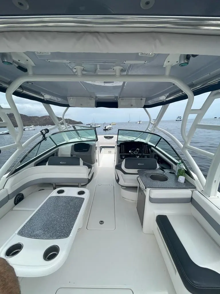 Walk-through windshield and twin consoles under the hardtop of a white dual console boat