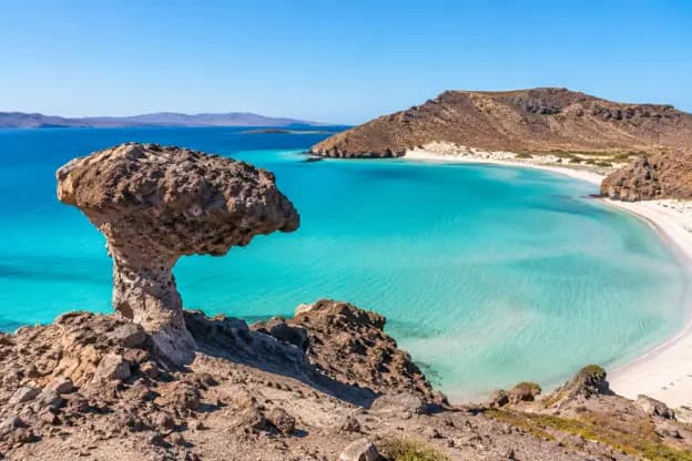 El Hongo rock formation overlooking the turquoise waters, white sandy beach and coastal hills of Balandra Beach in La Paz Mexico