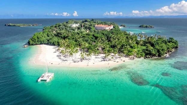 Sunny Samana beach with calm turquoise water and a boat trip in January