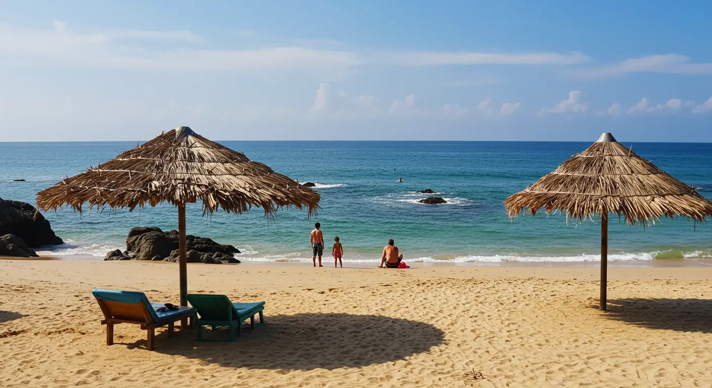 Thatched umbrellas and two lounge chairs on golden sand at Tamarindo Beach, a few people by the rocky shoreline