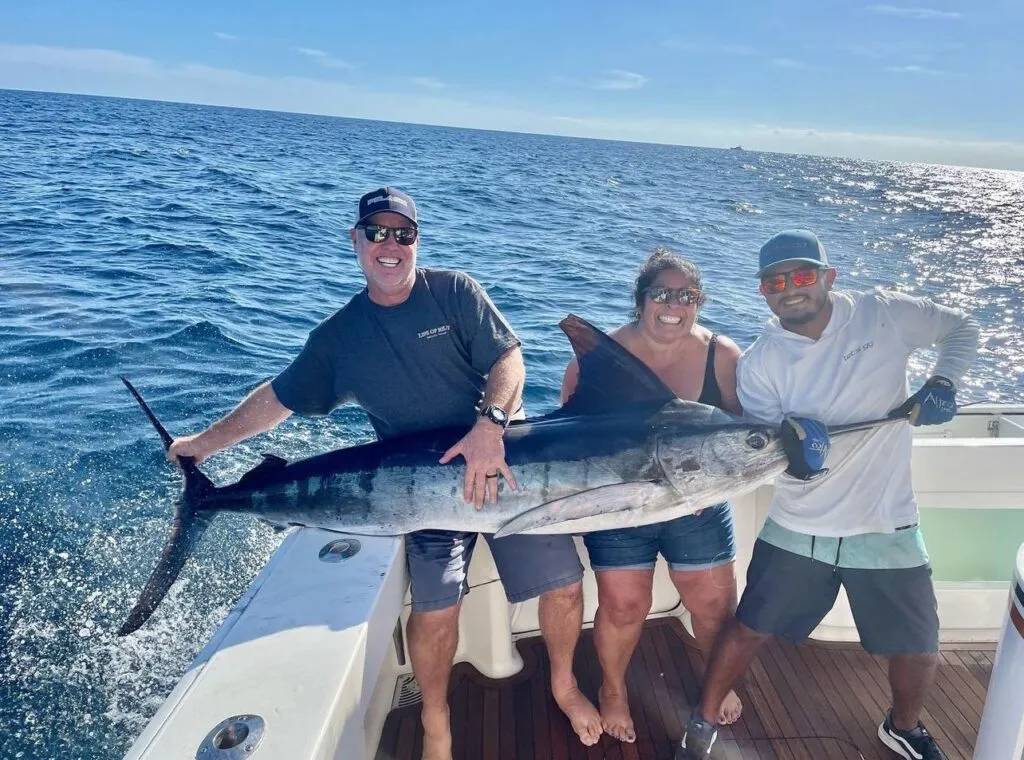Sportfishing group posing with a marlin during a deep-sea fishing trip in Cabo San Lucas.