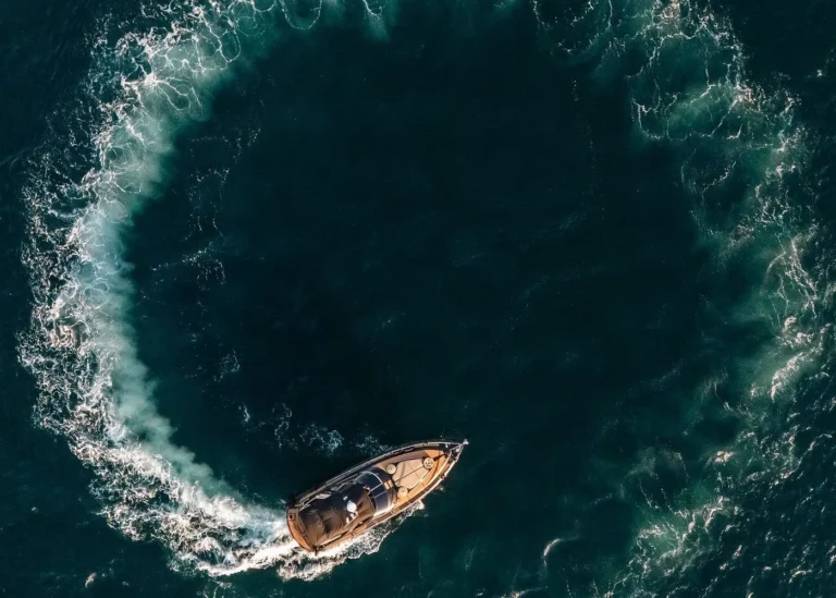 Things to Do in Cabo in June featuring a speedboat cruising across deep blue ocean water with a curved wake.