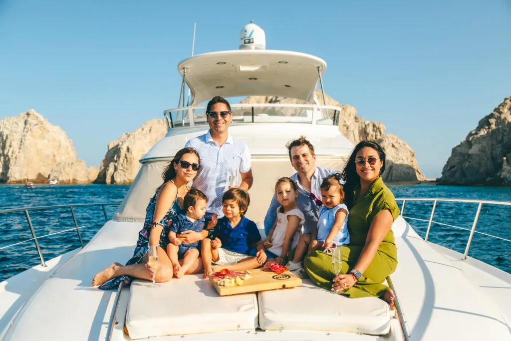 Family enjoying a Cabo Food Tour aboard a luxury yacht with ocean views and fresh local food.