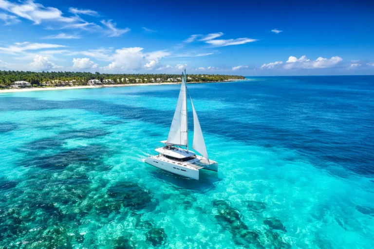 Best catamaran tours Cancun experience with a luxury white catamaran sailing on crystal-clear turquoise waters near Isla Mujeres coastline in high-definition landscape