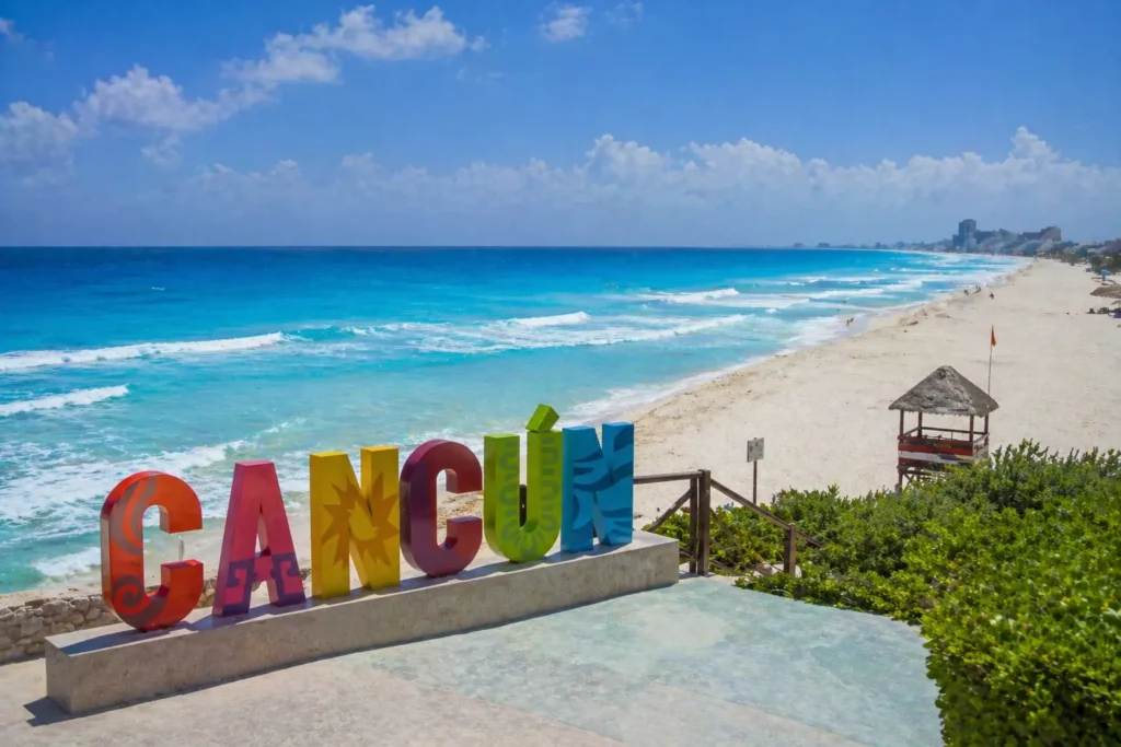 Playa Delfines beach with Cancun sign and ocean view showing a popular place to visit in Cancun with white sand and blue water