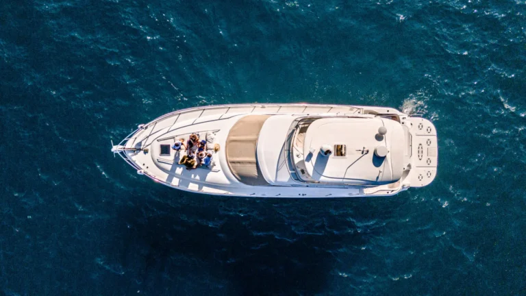 Cabo San Lucas Weather in March with a luxury boat cruising through deep blue ocean water under bright sunny skies.