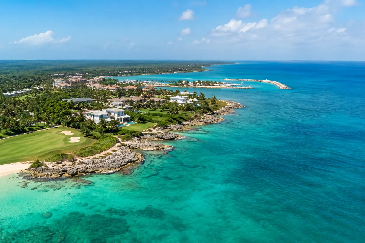Where Is Cap Cana aerial view showing the turquoise coastline, luxury marina, white villas, lush palm trees, and pristine Caribbean shoreline in the Dominican Republic.