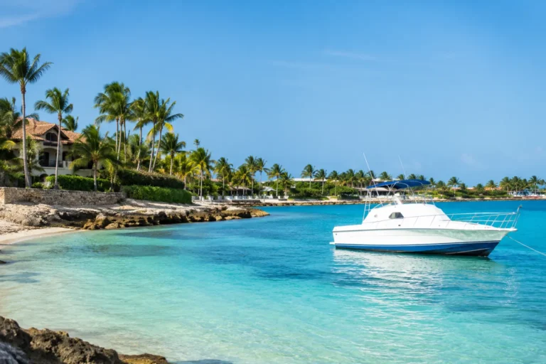 Secrets Cap Cana Excursions with a private boat anchored in crystal-clear turquoise waters along a tropical Caribbean shoreline
