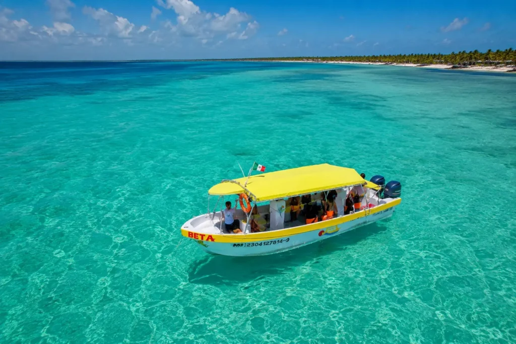 Private boat charter cruising across crystal-clear turquoise waters near the Cozumel coastline, offering a scenic and relaxing Caribbean boating experience.