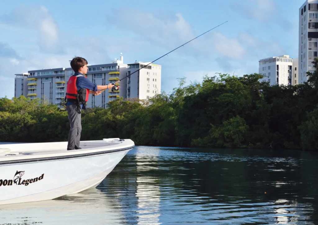 Half-day boat trip from San Juan Puerto Rico with a child fishing on a boat near the coast.