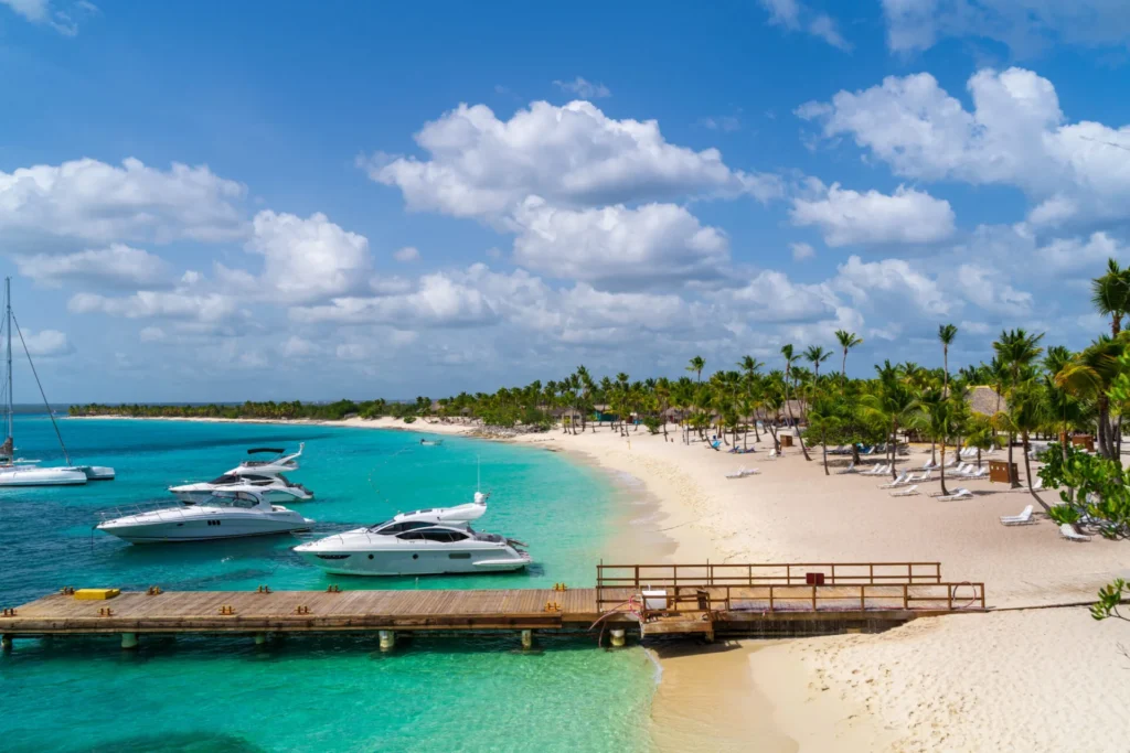 Private Saona Island Excursion with luxury yachts anchored beside a pristine white sand beach and turquoise Caribbean waters.