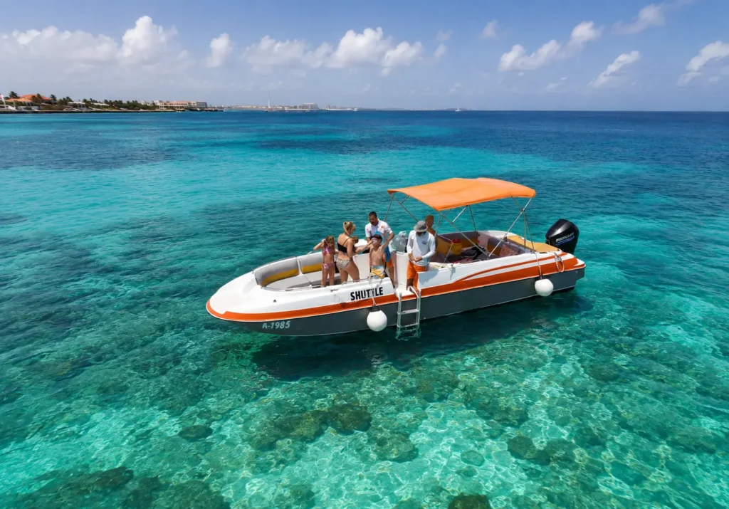 Premium Aruba boat tour on crystal-clear turquoise waters with a tropical coastline in the background.